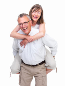 Portrait of a happy old man carrying old woman against white background
